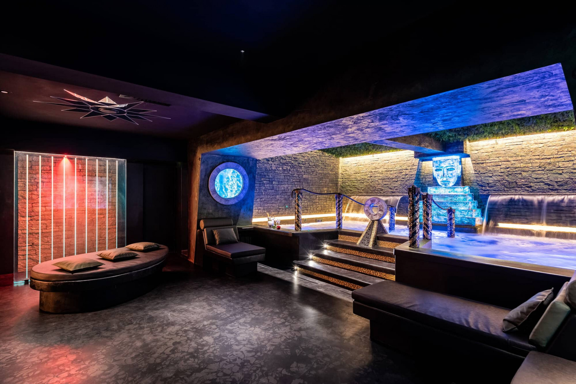 Spa area in Trilussa Palace Hotel with blue lights a pool and a mayan sculpture in the middle 